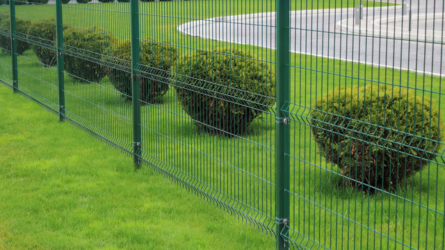 neat fence and bushes of the park area in the city