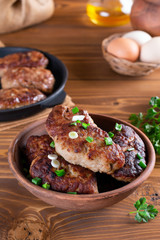 Homemade roasted beef cutlets in a ceramic bowl on wooden table