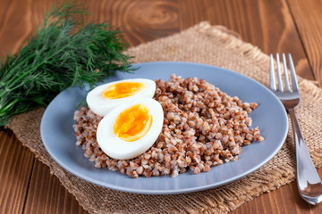 Buckwheat with vegetables on a wooden background.