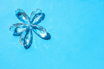 crystal on a blue background, transparent crystals in the shape of a flower, concept of clean water, ecology