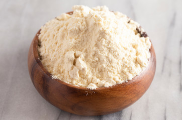 Fototapeta na wymiar Bowl of Millet Flour in a Wood Bowl on a White Marble Countertop