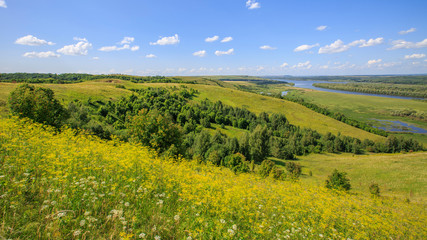 Fototapeta na wymiar hills overgrown with grass and trees on the banks of the Vyatka River