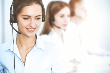 Call center operators. Focus on beautiful business woman using headset