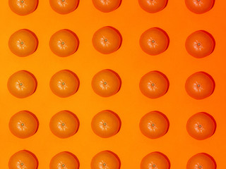 Colorful fruit pattern of fresh mandarins on an orange background. Top view
