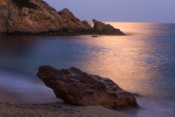 Fototapeta na wymiar Beach with rocks with reflection of light in the sea