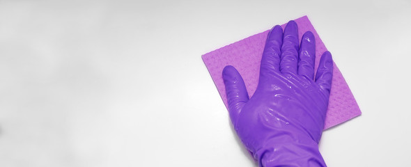 Close up photo of wiping surface in violet gloves with rag. Clea