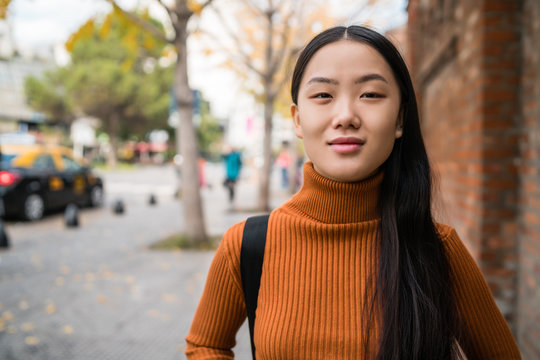 Portrait of young Asian woman in the street.