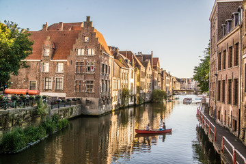 Fototapeta na wymiar canoe in canal with colorful homes in belgium