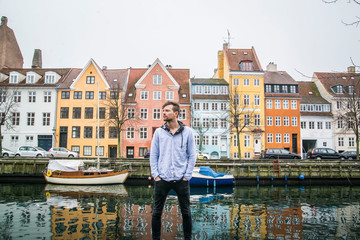 Naklejka premium Traveler in front of colorful townhomes of Copenhagen Denmark 