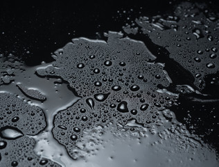 Drops of water on a black plastic surface