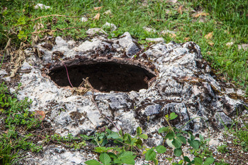 An ancient pit in the southern Caucasus mountains where clay kvevris filled with wine were stored over the winter surrounded by grass and vines - shallow focus