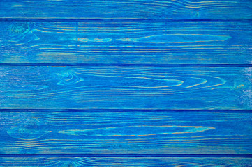 The texture of a wooden background consisting of boards painted with blue paint, designed for photographs.