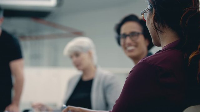 Young woman talking in a meeting and clapping. Business people clapping hands after a successful meeting.
