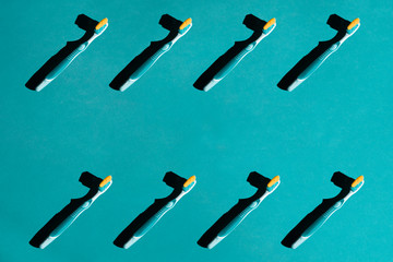 Plastic toothbrushes on a blue pastel background. Pattern