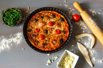 Pizza with salami , mozzarella , tomato and olives . Optional you can add arugula .