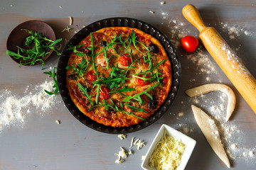 Pizza with salami ,mozzarela ,tomato and arugula .