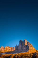 View over beautiful red sunset in magical Three Dolomite peaks at the national park Three Peaks (Tre Cime, Drei Zinnen) at blue sky, South Tyrol, Italy, cover page