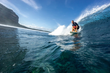muscular surfer riding on big waves on the Indian Ocean island of Mauritius