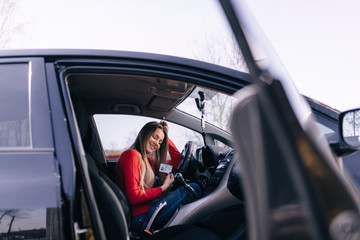 Black car driver woman smiling showing new driver's license
