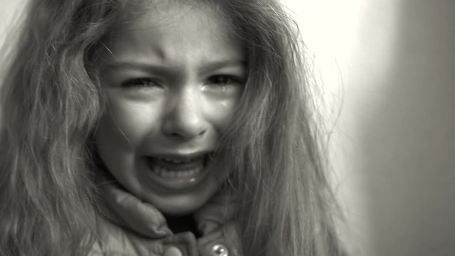 Sad child crying. Little girl is sad with tears on the face. Portrait of kid with tears.
