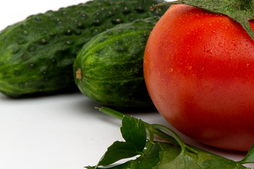whole juicy bright red tomatoes with green cucumber isolated on a white background