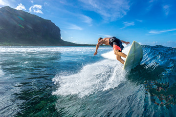 muscular surfer riding on big waves on the Indian Ocean island of Mauritius