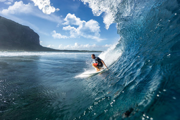 muscular surfer riding on big waves on the Indian Ocean island of Mauritius - obrazy, fototapety, plakaty