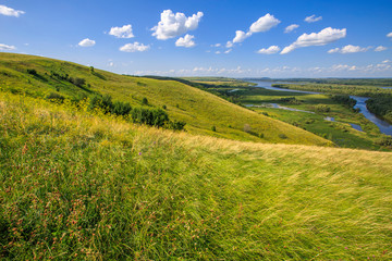 Fototapeta premium hills overgrown with grass and trees on the banks of the Vyatka River