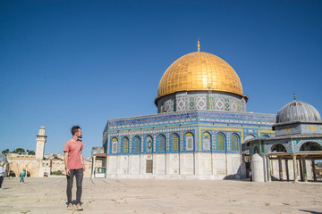 male traveler walking to the dome of the rock in jerusalem israel