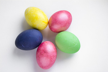 Easter festive multi-colored mother-of-pearl chicken eggs lay on a white background