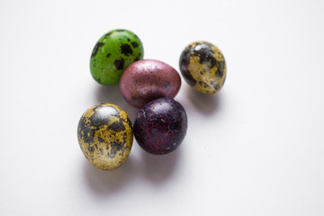Easter multicolored quail spotted eggs lie on a white background