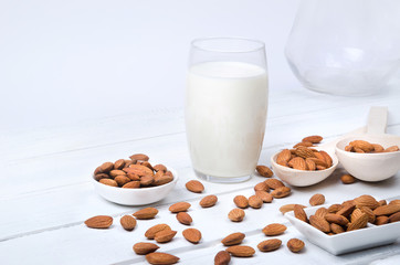 Oatmeal milk with oat seeds on wooden background