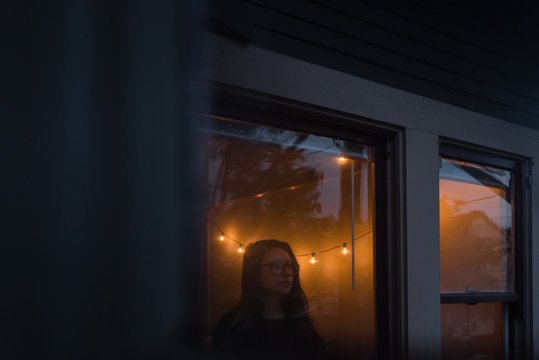 Person looking out window at night