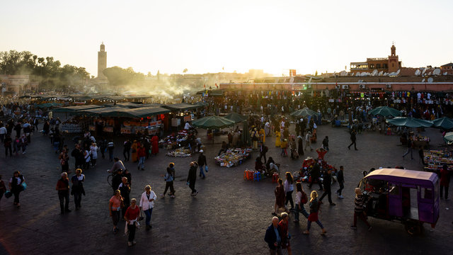 Marrakesh, Morocco - 04/05/2018: Tourists visiting Place Jemaa el Fna at sunset