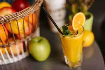 Close up of orange juice next to fruit on table