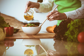 Unknown human hands cooking in kitchen. Woman is busy with vegetable salad. Healthy meal, and vegetarian food concept
