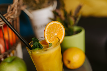 Close up of orange juice next to fruit on table
