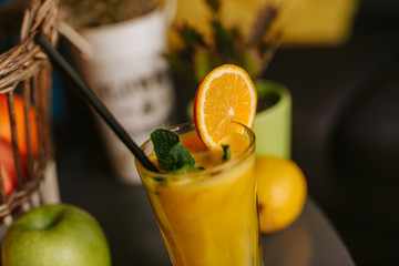 Close up of orange juice next to fruit on table