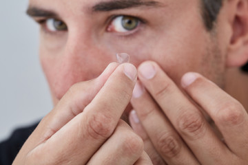 Man removing contact lens