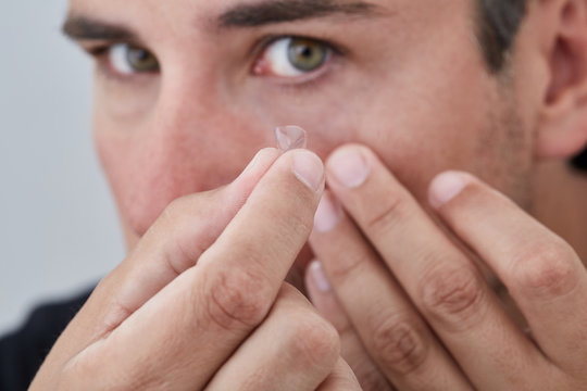 Man removing contact lens