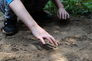 Rysowanie palcem po piasku.