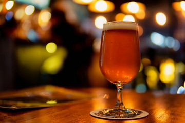  A glass of lager beer on the wooden table and bokeh background.  Copy Space for text.