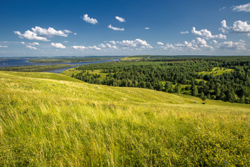 Obraz premium hills overgrown with grass and trees on the banks of the Vyatka River