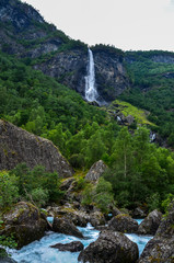 Giant Rjoandefossen waterfall among the mountains  flows down in the beautiful mountain river canyon. Flam, Norway landscape. Beauty in nature.