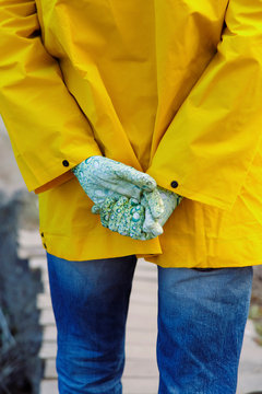 Person standing folding hands behind back