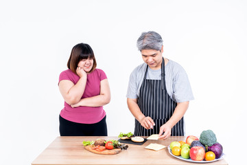 Portrait images of Asian wife and husband Obese are smiling and happiness To cooking a hamburger That they are prepared On white background, to Asian family and fastfood concept.