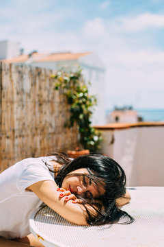 Girl resting her head on a table.