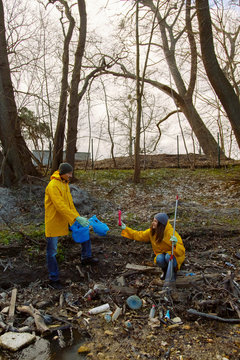 People in yellow raincoats sorting plastic garbage