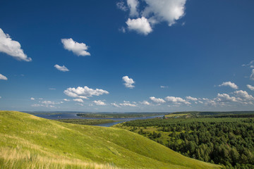 Fototapeta premium hills overgrown with grass and trees on the banks of the Vyatka River