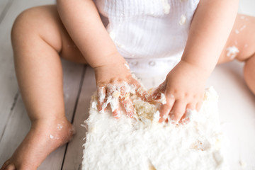 First birthday cake smash close up details, baby covered in white coconut cake. close up images of the mess. 